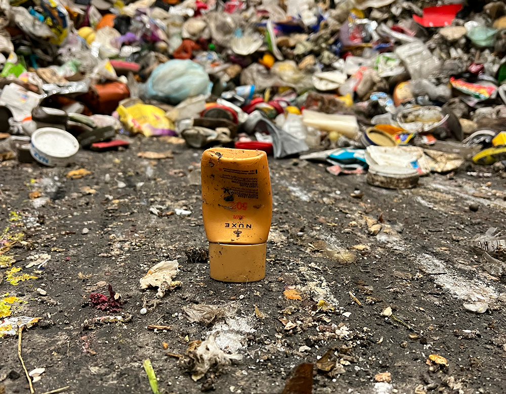 En liten kremtube foran en haug av små biter med avfall